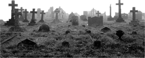 Fotografia em preto e branco de um cemitério antigo com cruzes e lápides sobre a grama, sob a neblina