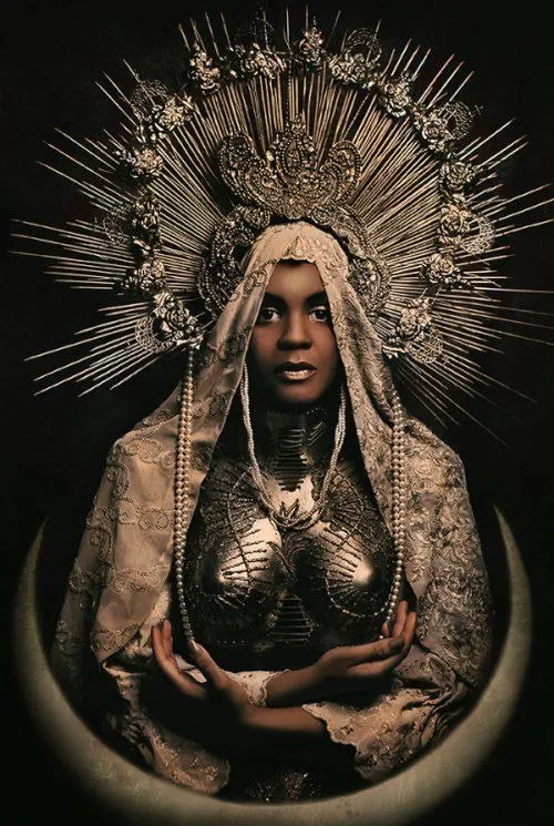 Fotografia de mulher negra caracterizada como Nossa Senhora, com véu rendado e grande resplendor dourado ao redor da cabeça